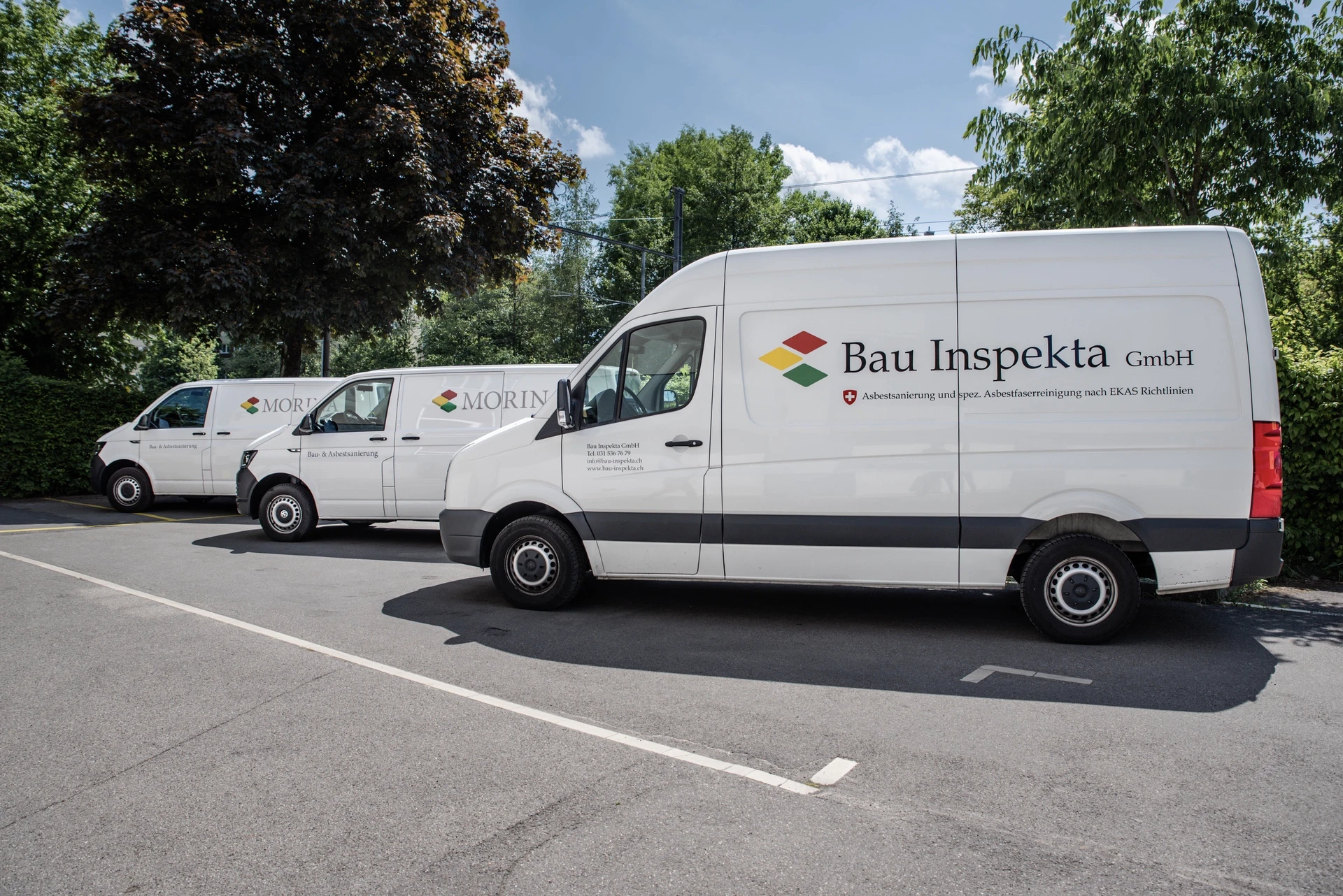 Fahrzeugflotte der Bau Inspekta GmbH mit Firmenbeschriftung Asbestsanierung und Asbestfaserreinigung nach EKAS-Richtlinien