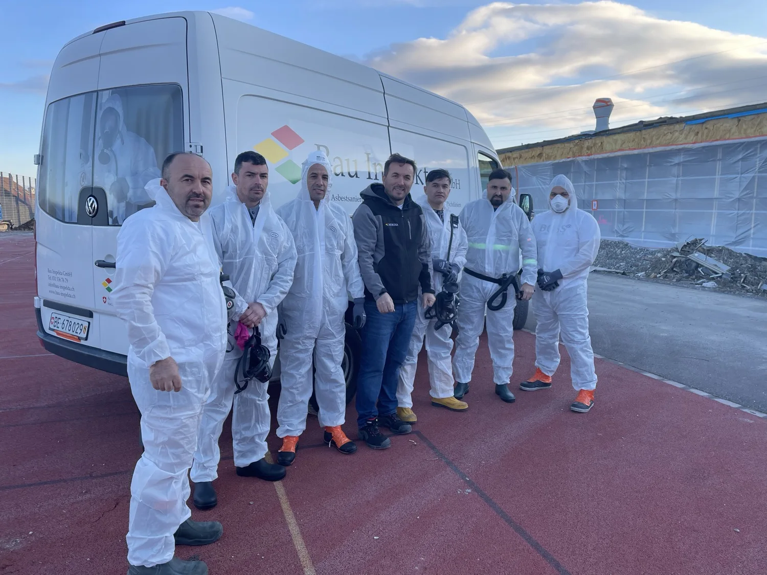 Das Team der Bau Inspekta GmbH mit Geschäftsführung und Mitarbeitern vor einem Firmenfahrzeug